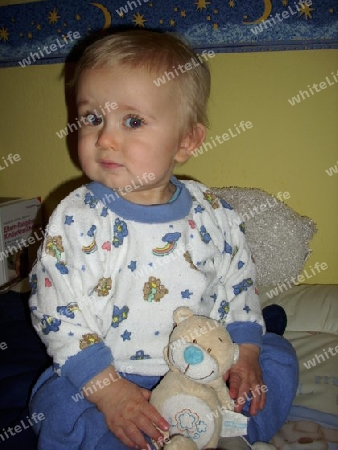 Baby im Schlafanzug mit Teddy