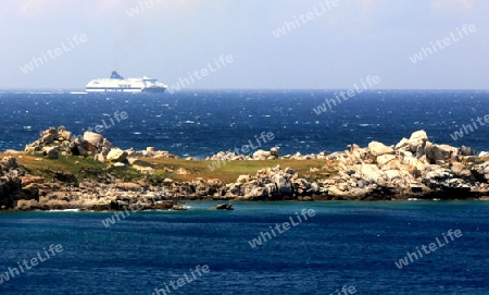 Felseninsel im Meer und Schiff im Hintergrund