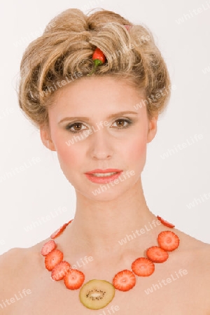 Attraktive blonde junge Frau mit Erdbeere-Kiwi- Kette  / Attractive blonde young woman with strawberry-kiwi-chain