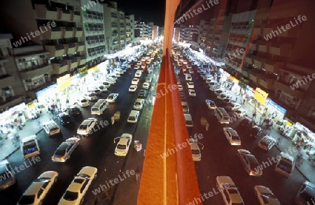 a road at night in the old town in the city of Dubai in the Arab Emirates in the Gulf of Arabia.