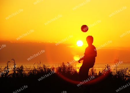 Young soccer player at training at sunset - Junger Fussballer beim abendlichen Training bei Sonnenuntergang              