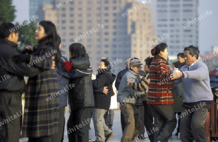 people dancing in the morning on the Bund in front of the skyline of Pudong in the City Shanghai in China.