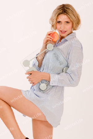 Junge Frau mit Waage und Apfel / Young girl eating apple and carrying set of scales