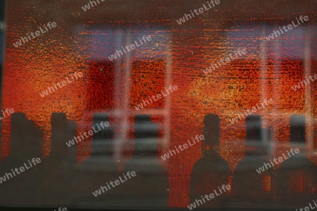 Flaschen hinter einem roten Fensterglass