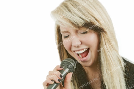 Junge Frau singt in ein Mikrofon