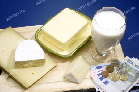 Milchprodukte mit Eurom?nzen und Euroscheinen auf blauem Hintergrund