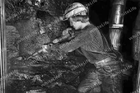 Jungbergmann mit Abbauhammer im Streb beim Kohle abbauen