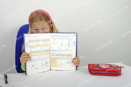 junge Sch?lerin zeigt schwierige Formeln in einem Schulbuch und verdreht deswegen die Augen