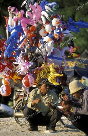 a men sales ballons at the beach at the coast of the Town of Sihanoukville in cambodia in southeastasia. 