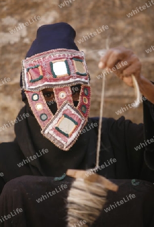 a Beduin women at work to spinning woll in the Temple city of Petra in Jordan in the middle east.