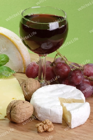 Rotwein mit K?se und Weintrauben auf gr?nem Hintergrund