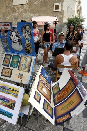 a Painter in the old Town of  Taormina in Sicily in south Italy in Europe.