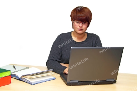 Junge lernende Frau am Schreibtisch sitzend