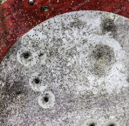 Detailed close up of bullet holes from gun shots in a german traffic sign