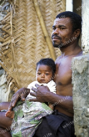 a men with his child in the city of Moutsamudu on the Island of Anjouan on the Comoros Ilands in the Indian Ocean in Africa.   