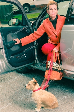 Attraktive Frau mit einem Hund verl?sst ein Auto