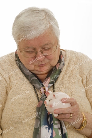 Seniorin mit Sparschwein auf hellem Hintergrund