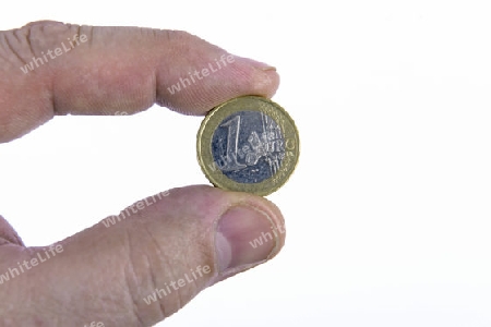 1 Euro Muenze, zwischen den Fingern einer Hand