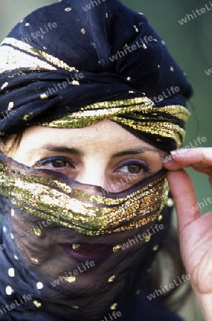 Eine Tunesische Frau in traditionellem Kopftuch  in Monastir am Mittelmeer im Nordosten von Tunesien in Nordafrika.