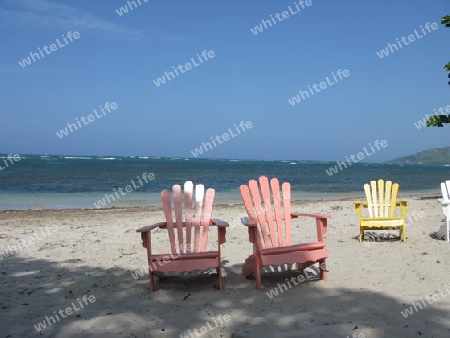Dominikanische Republik. Bunte Sessel am Strand