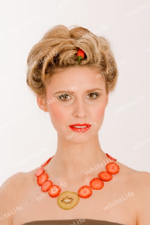 Attraktive blonde junge Frau mit Erdbeere-Kiwi- Kette  / Attractive blonde young woman with strawberry-kiwi-chain